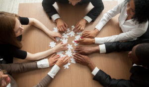 Diverse,Team,People,Assembling,Jigsaw,Puzzle,,Multiracial,Group,Of,Black